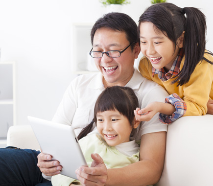 A parent learning with two children using a tablet